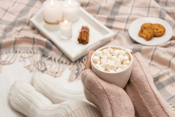 cozy-person-holding-mug-with-hot-cocoa-marshmallows